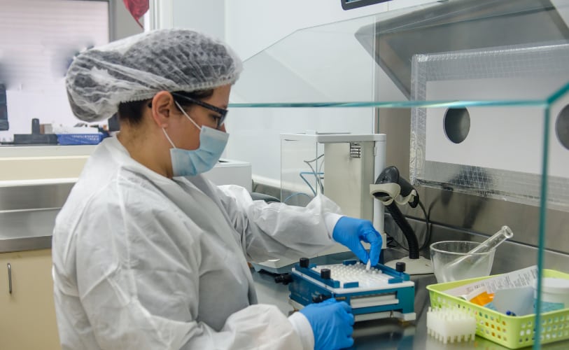 Laboratory technician preparing medication in a controlled workspace